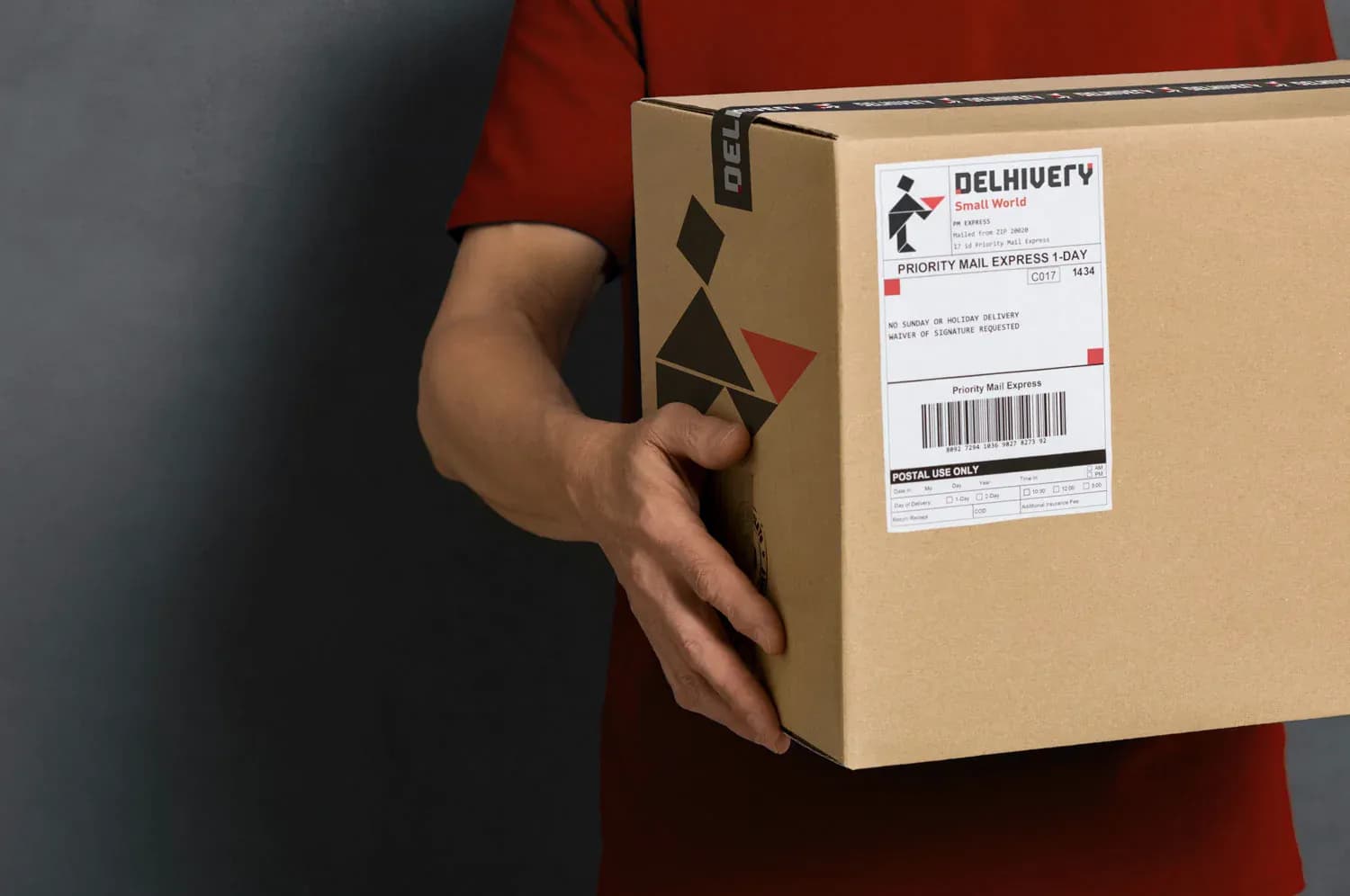 Courier carrying a Delhivery box
