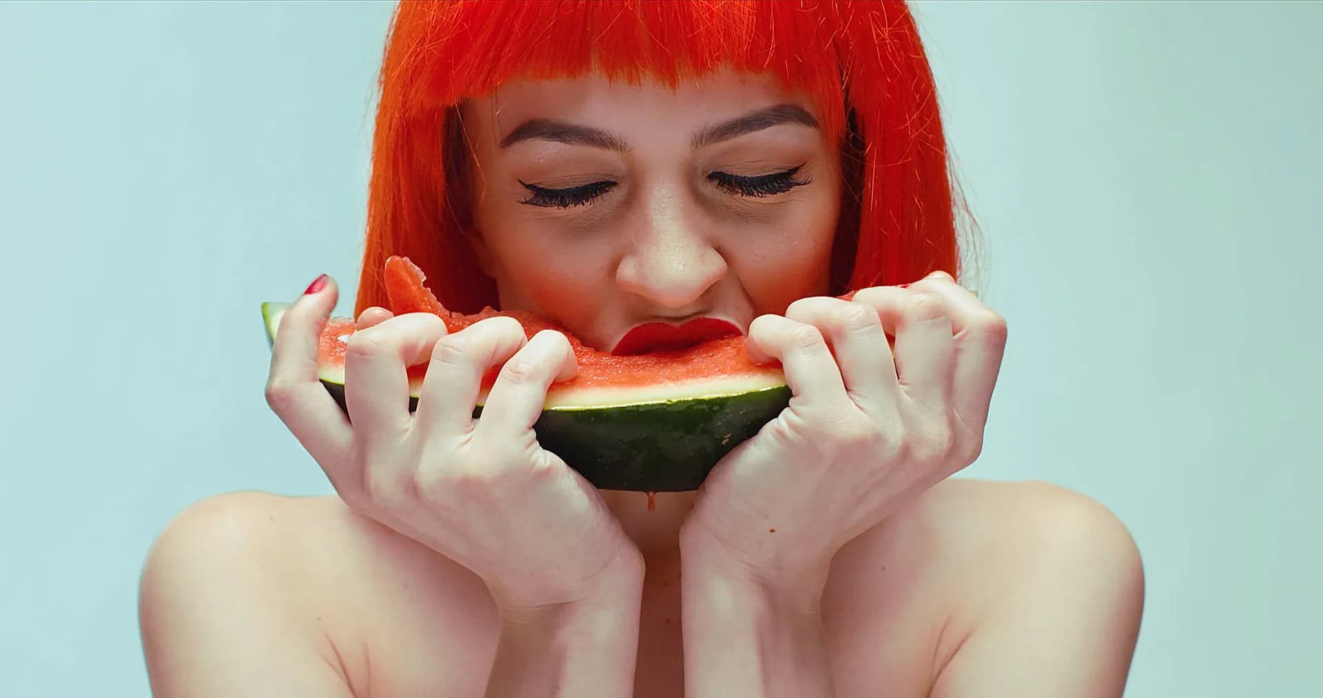 Woman with red hair biting into watermelon, OnePlus campaign